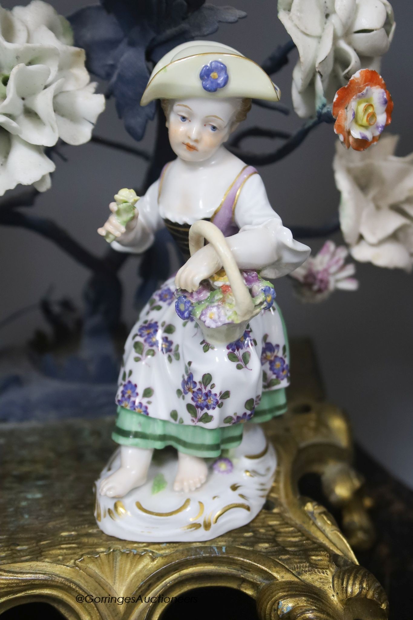 A 19th century and later Continental porcelain and ormolu floral timepiece with Meissen figure